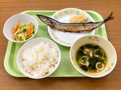 大きなさんまの塩焼きを中心に、ご飯や汁物、野菜のおかずが並ぶ、秋の味覚たっぷりの給食です。